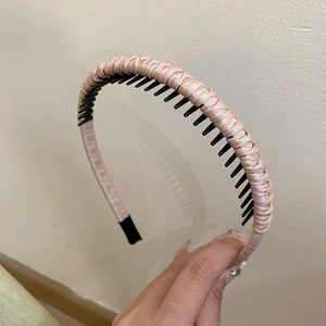 Detail of pink satin woven headband showing non-slip inner comb and high-quality texture