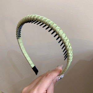 Close-up of light green woven headband featuring non-slip inner teeth and satin fabric