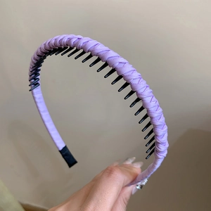 Detail of purple braided headband with non-slip black plastic inner teeth for hair