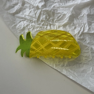 Detailed macro view of a pineapple hair claw clip made of yellow translucent acrylic