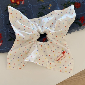 Polka dot hair scrunchie in white fabric with colorful dots and cherry logo tag