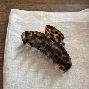 Elegant caramel tortoiseshell French hair claw clip for bun styles on wood background