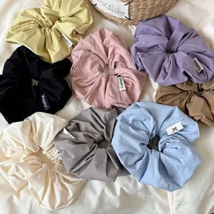 Colorful set of cream-colored pleated scrunchies with soft fabric textures on white sheet