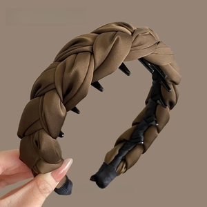 Détail du serre-tête tressé marron café avec texture satinée et peigne de maintien interne