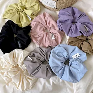 Set of 8 colorful cream-colored fabric scrunchies in pastel tones on a soft background