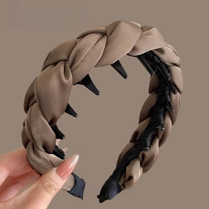 Détail d'un serre-tête tressé large taupe avec des dents de peigne internes antidérapantes