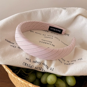 Détail d'un serre-tête rose à pois avec texture tissée et étiquette faite main