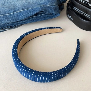Close-up of navy blue polka dot headband with non-slip brown suede inner lining