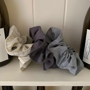 Trois chouchous à rayures minimalistes en crème, gris et bleu avec breloques cœur