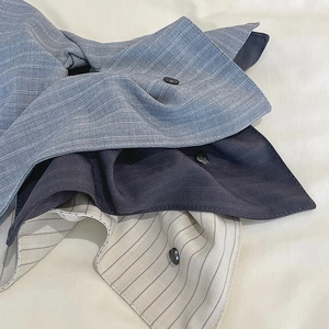 Detail shot of striped fabric textures with buttons in blue, grey, and off-white