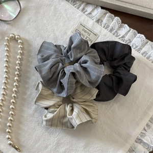 Détails de trois chouchous à rayures gris et beige avec une texture en coton et lin