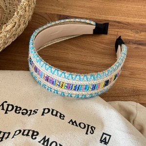 Detailed view of bohemian braided headband featuring colorful geometric embroidery patterns