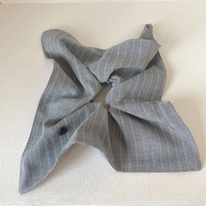 Detail of grey striped fabric hair scrunchie with small black heart metal ornament