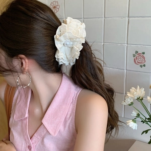 Elegant cream lace flower hair claw with pearl detail for women in a half-up hairstyle