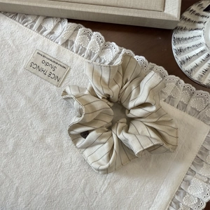 Gros plan d'un chouchou rayé sur un tissu en dentelle montrant la texture du tissu