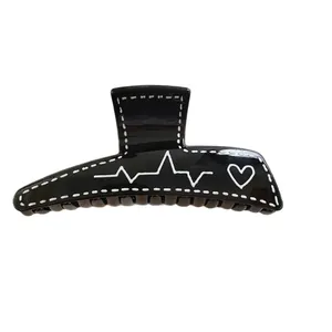 Pince à cheveux trapèze noire brillante avec graffiti coeur blanc et surpiqûres