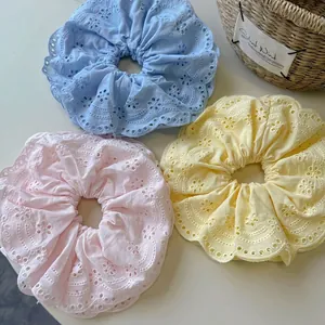 Three-pack of pastel cotton scrunchies with intricate hollow embroidery and wavy edges