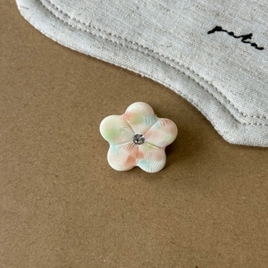 Detailaufnahme von kleiner Blumen-Haarklammer mit Strass und buntem Acetat-Muster