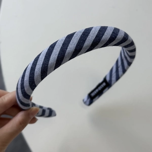 Detailed macro view of the blue and white striped fabric headband with handmade label