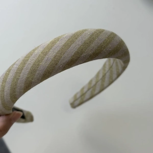 Detail of olive green striped fabric headband showing woven texture and anti-slip lining