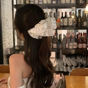 French style white satin scrunchie with black polka dots on a woman's hair