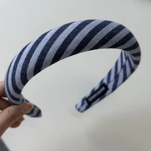 Detailed view of handmade thick striped fabric headband with blue and white diagonal patterns