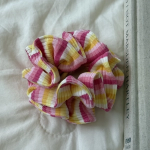 Gros plan d'un chouchou tricoté à rayures roses et jaunes montrant la texture et le tissu