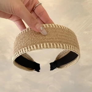 Bohemian woven straw headband with white stitching and a natural khaki finish