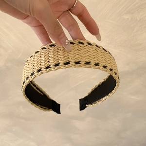 Close-up of bohemian woven straw wide headband with black edge stitching and non-slip lining