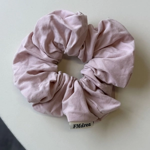 Dettaglio ravvicinato della trama dell'elastico in maglia rosa con etichetta logo