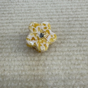 Detailansicht der kleinen Acetat-Haarklammer in Blumenform mit gelber Marmorierung und Strass
