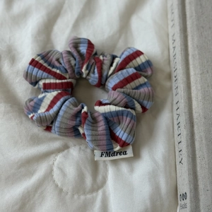 Gros plan sur la texture en maille à rayures colorées et l'étiquette en tissu du chouchou
