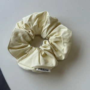 Dettaglio di un elastico in tessuto giallo tenue con etichetta tessile del marchio FMdrea