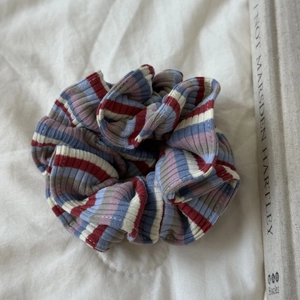 Vue détaillée d'un chouchou en maille rayée avec des motifs doux rouge bleu et blanc