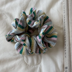 Détail d'un chouchou en maille rayée avec des motifs roses, bleus et jaunes