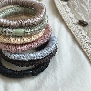 Detail shot of multi-colored ribbed silk scrunchies with smooth texture and soft sheen