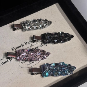 Détail de quatre barrettes en zircon étincelant en blanc, gris, rose et bleu-vert brillant