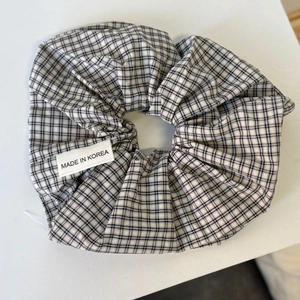Vintage zwart-wit geruite haarelastiekje met Made in Korea label op grijze basis