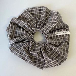 Close-up van een vintage ruitjes scrunchie met klassiek patroon en ingenaaid stoffen label