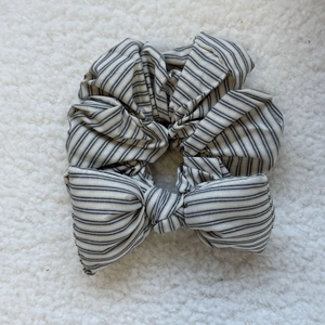 Detail of grey plaid sponge bow scrunchie with soft cotton texture on plush background