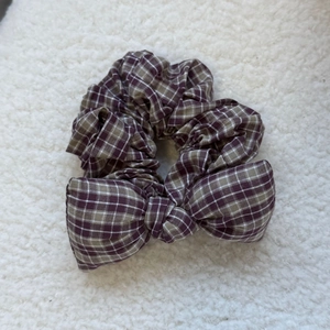 Close-up detail of the vintage purple plaid bow scrunchie with sponge filling on soft fur
