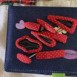 Vintage red polka dot fabric hair clip set including various shapes on denim background