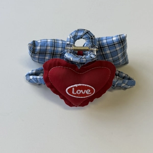 Detailed view of blue checkered hair claw clip with a red embroidered heart showing Love
