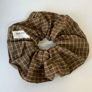 Macro detail van geruite scrunchie met een wit handgemaakt textieletiket