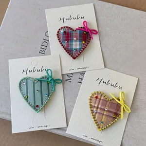 Trois barrettes cœur en tissu à carreaux avec strass colorés et nœuds sur carte