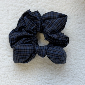 Retro blue and black plaid hair scrunchie with sponge bow tie on white plush background