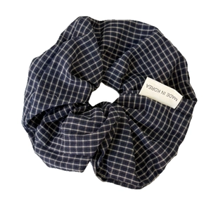 Klassieke blauw en wit geblokte stoffen scrunchie met Made in Korea label op witte achtergrond