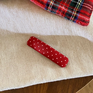 Macro shot of red and white polka dot fabric hair clip with detailed textile texture