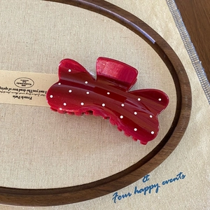 Detail view of red polka dot hair claw clip with French vintage acetate texture