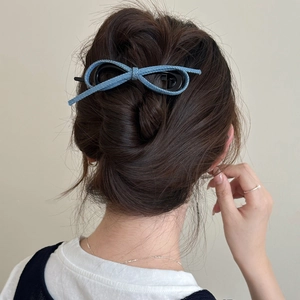 Pince à cheveux nœud en denim bleu pour coiffures élégantes sur fond minimaliste